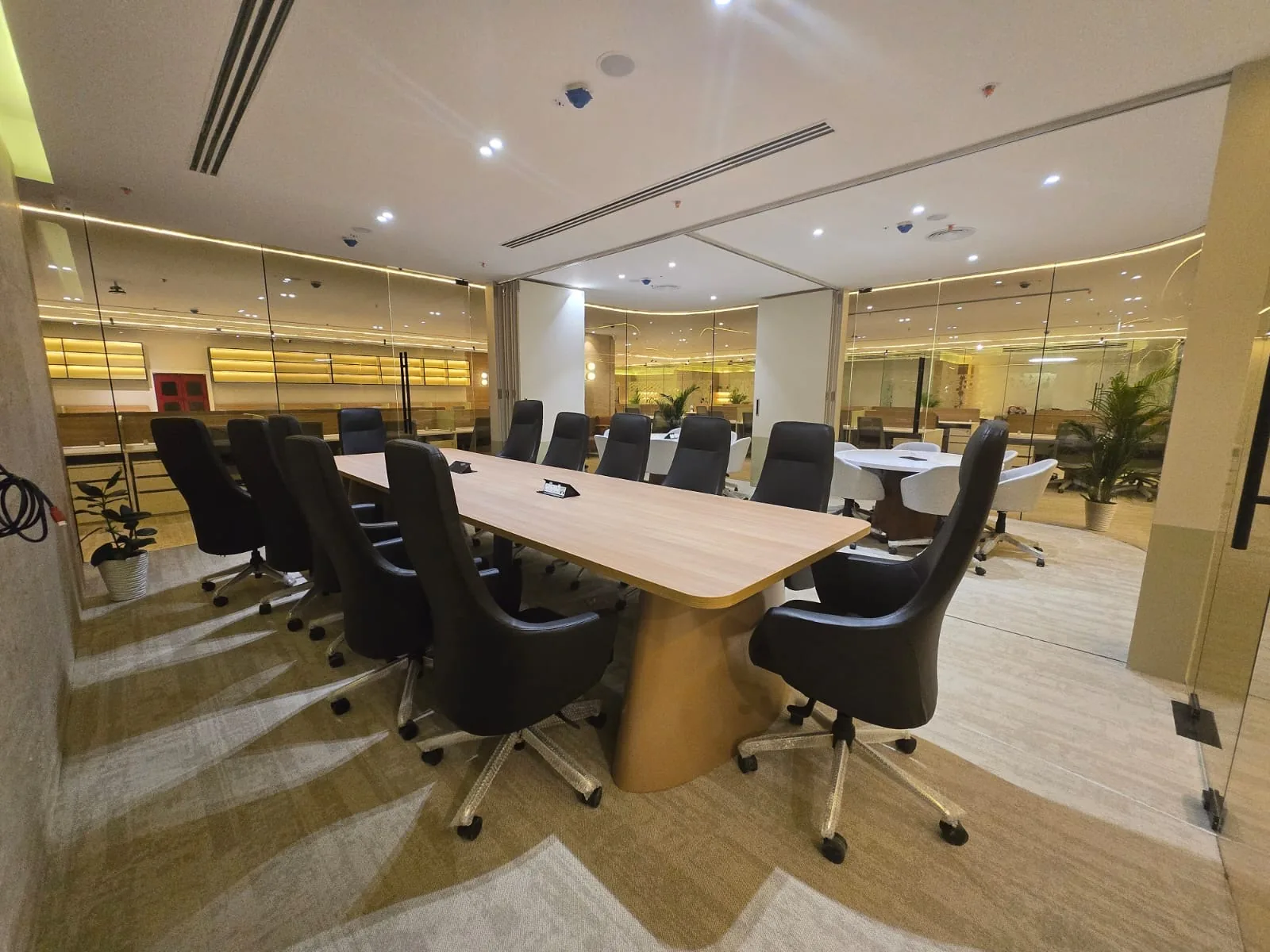 A premium-tier boardroom with statement lighting and glazed partitions