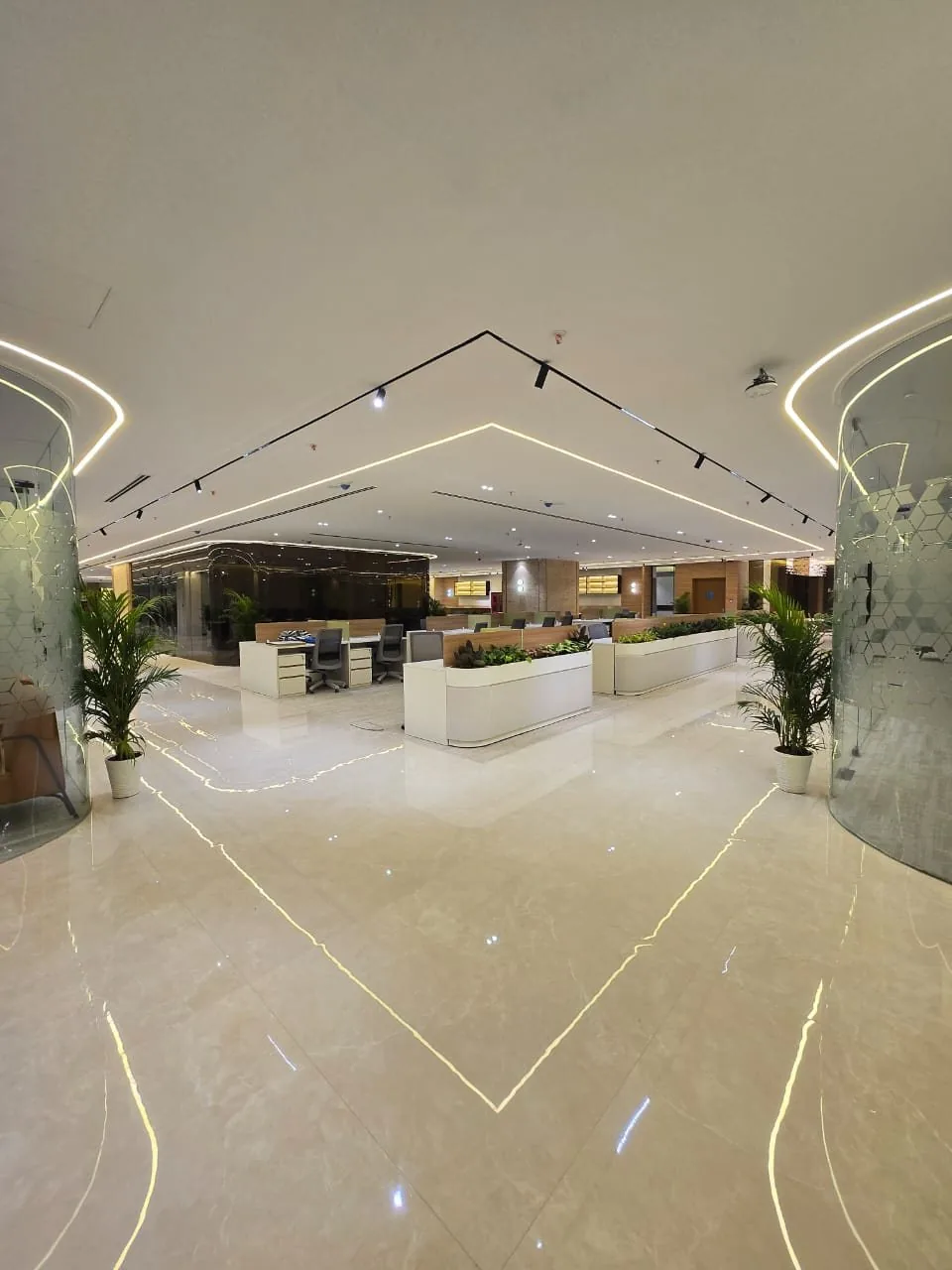 Marble-floored central area with inlaid light lines, frosted glass rooms and planted workstation dividers