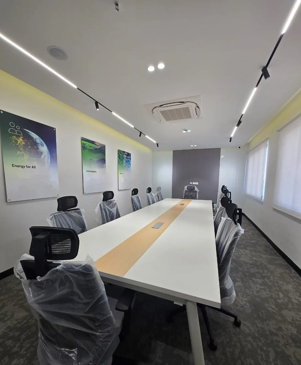 Meeting room with a long white table, track lighting and framed wall graphics